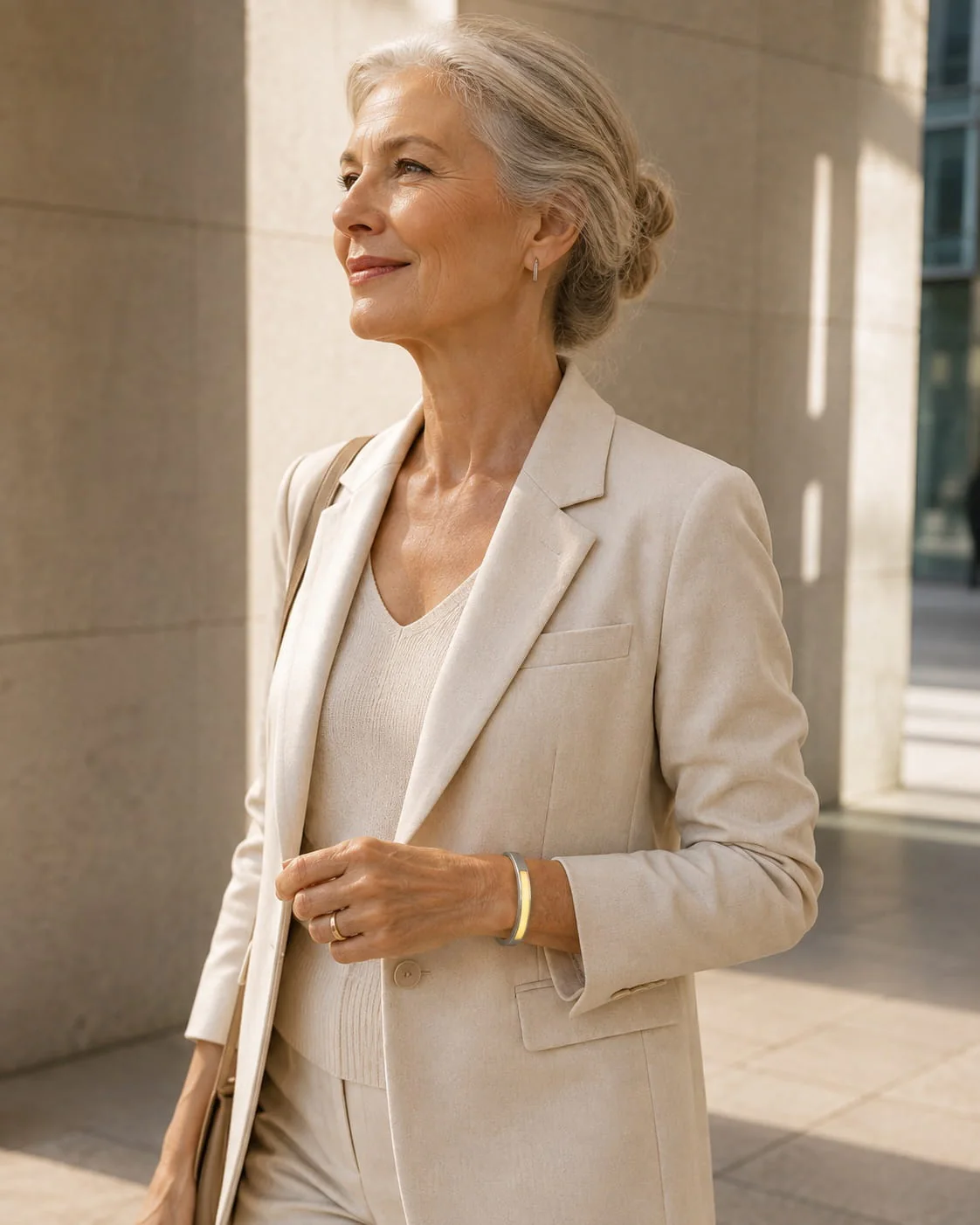 Woman wearing a yellow-illuminated JUVEIL bangle in a bright architectural setting.
